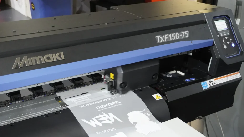 Mimaki TxF150-75 DTF printer performing DTF print on a Direct to Film sheet with high precision and quality.